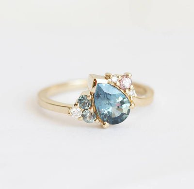 Blue pear-shaped sapphire ring with diamond cluster