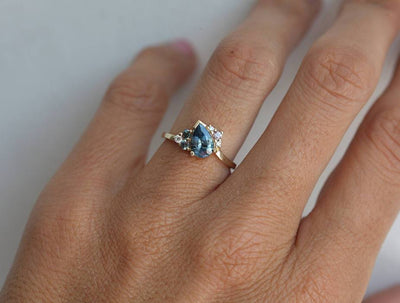 Blue pear-shaped sapphire ring with diamond cluster