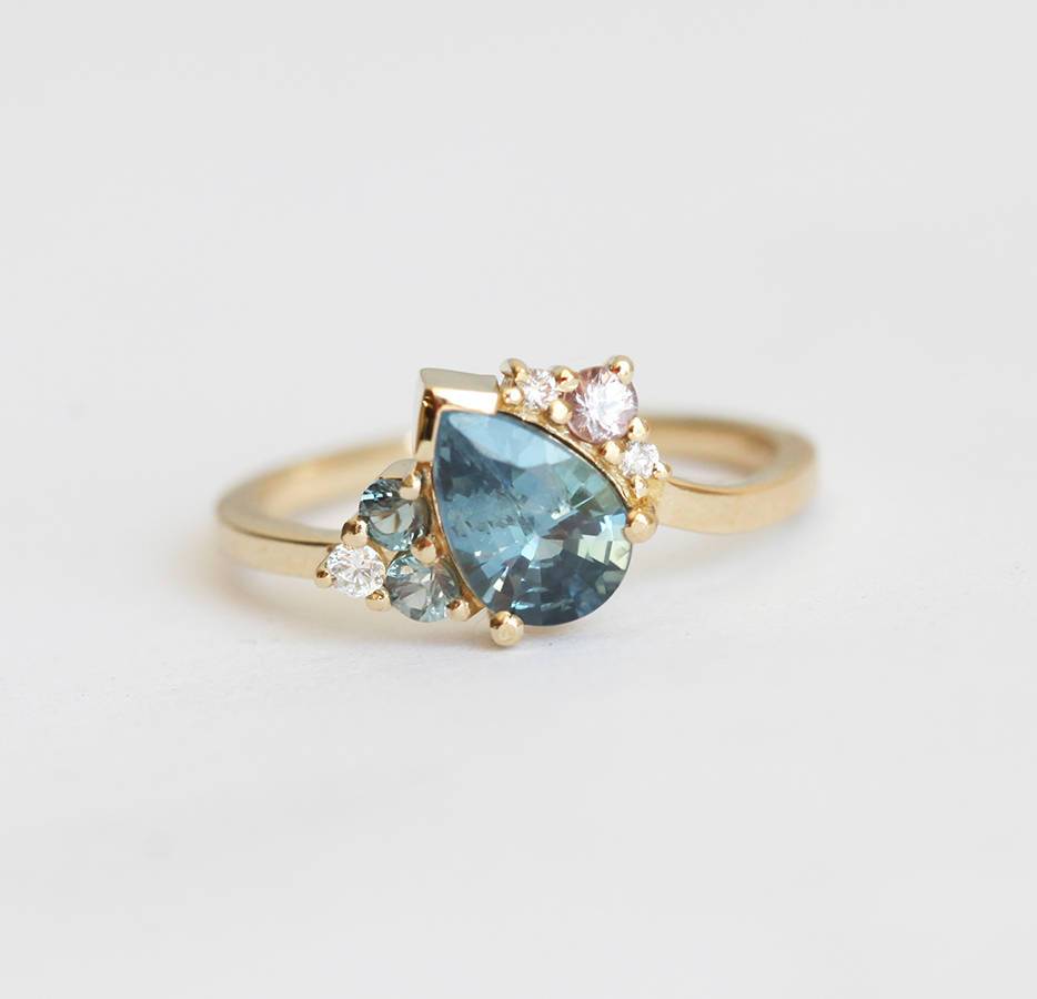 Blue pear-shaped sapphire ring with diamond cluster