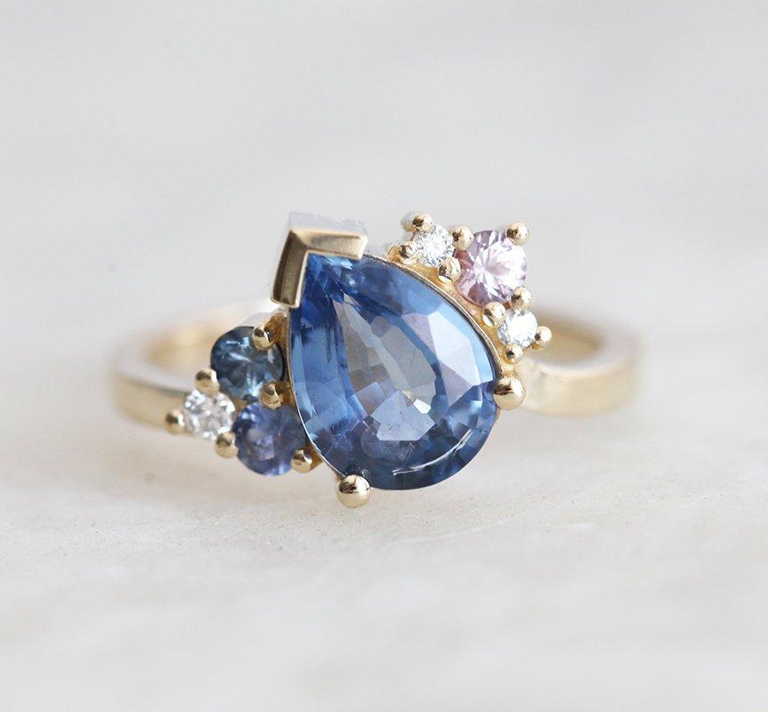 Blue pear-shaped sapphire ring with diamond cluster