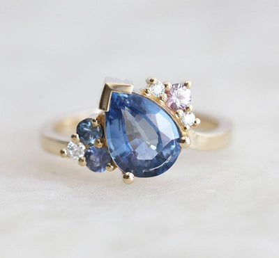 Blue pear-shaped sapphire ring with diamond cluster