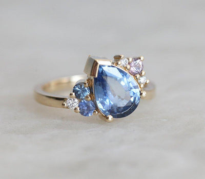 Blue pear-shaped sapphire ring with diamond cluster