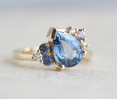 Blue pear-shaped sapphire ring with diamond cluster