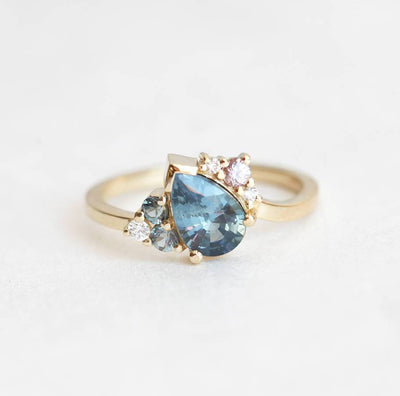 Blue pear-shaped sapphire ring with diamond cluster