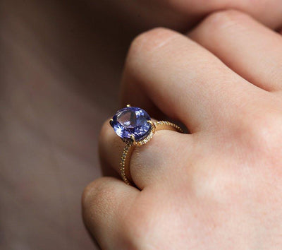 Purple Oval Tanzanite Yellow Gold Ring with Round White Diamonds Nested in the Band