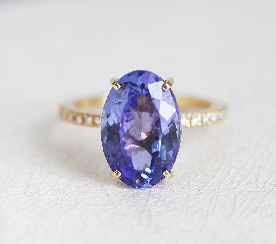 Purple Oval Tanzanite Yellow Gold Ring with Round White Diamonds Nested in the Band