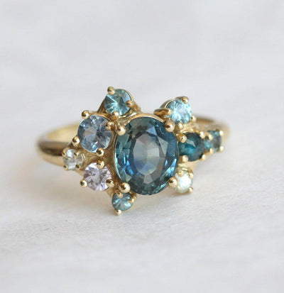 Blue oval-shaped sapphire ring with diamond cluster