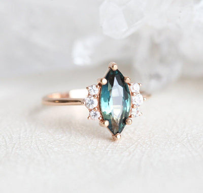 Vintage marquise-shaped teal sapphire ring with side diamonds