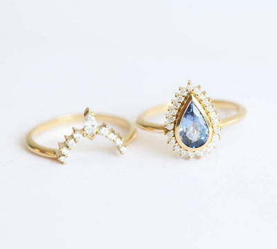 Pear-shaped blue sapphire ring with diamond halo and matching diamond band