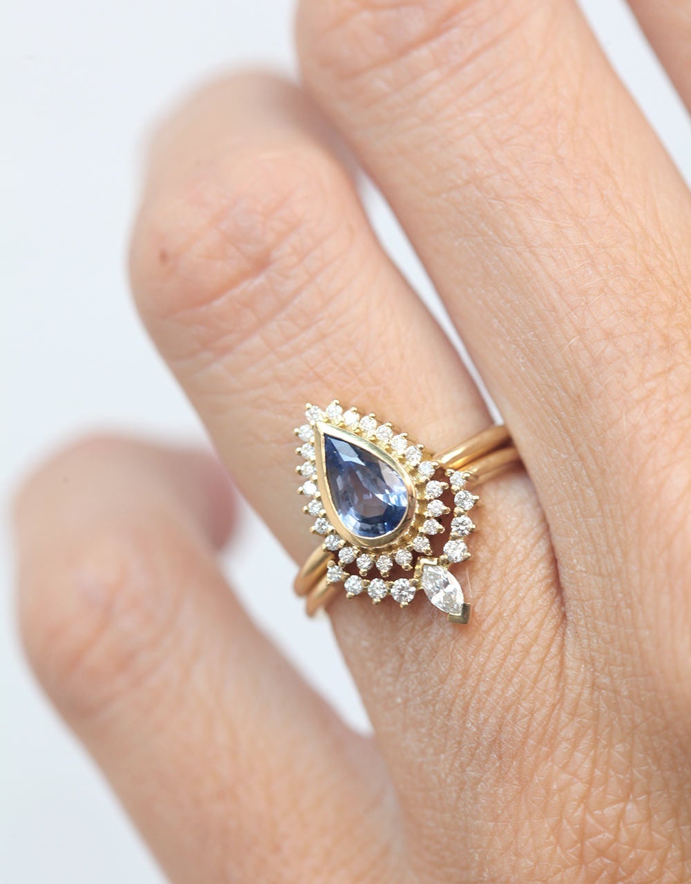 Pear-shaped blue sapphire ring with diamond halo