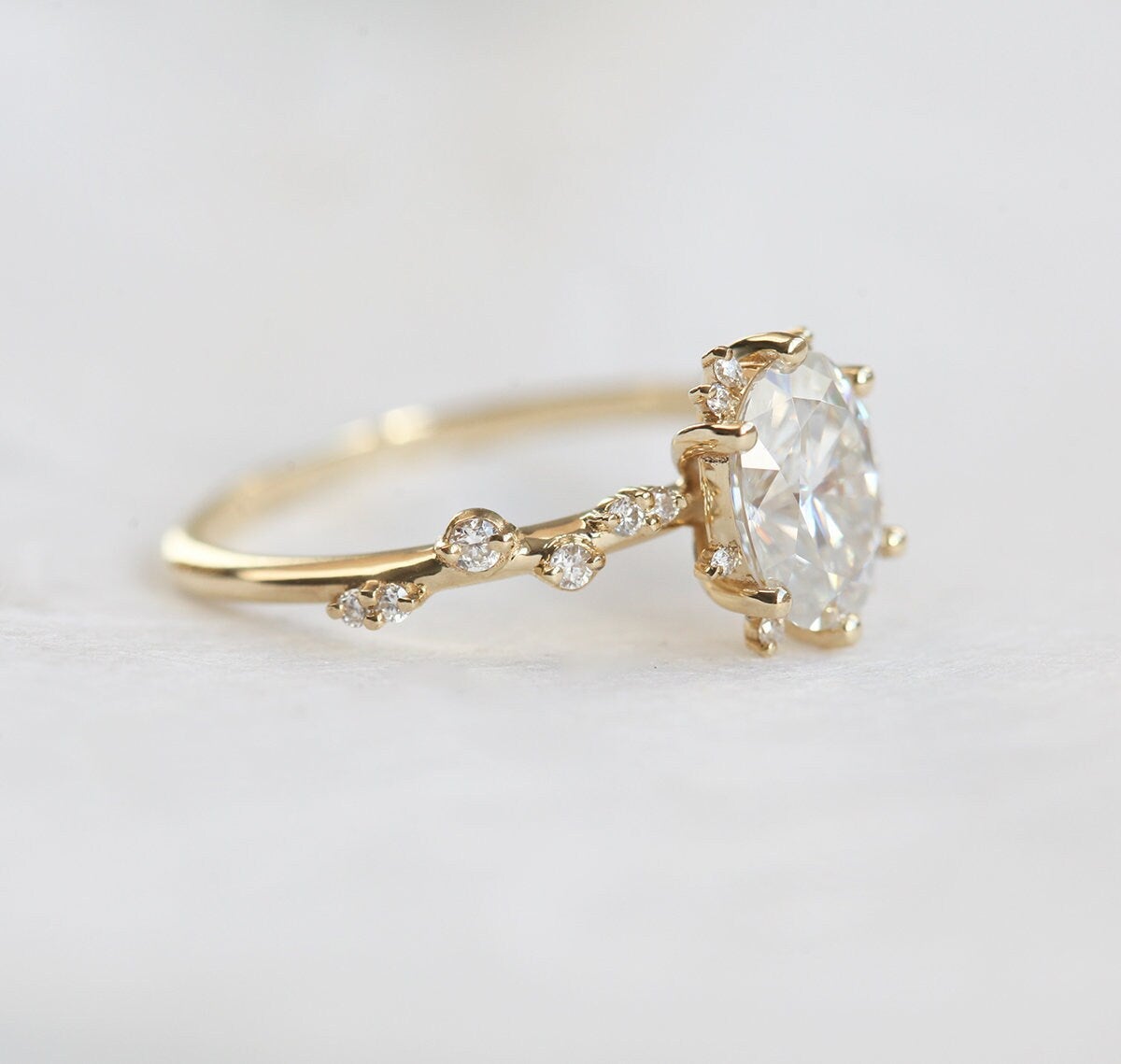 Oval White Diamond Cluster Ring with Side White Round Diamonds Placed like a vine leading to the center stone