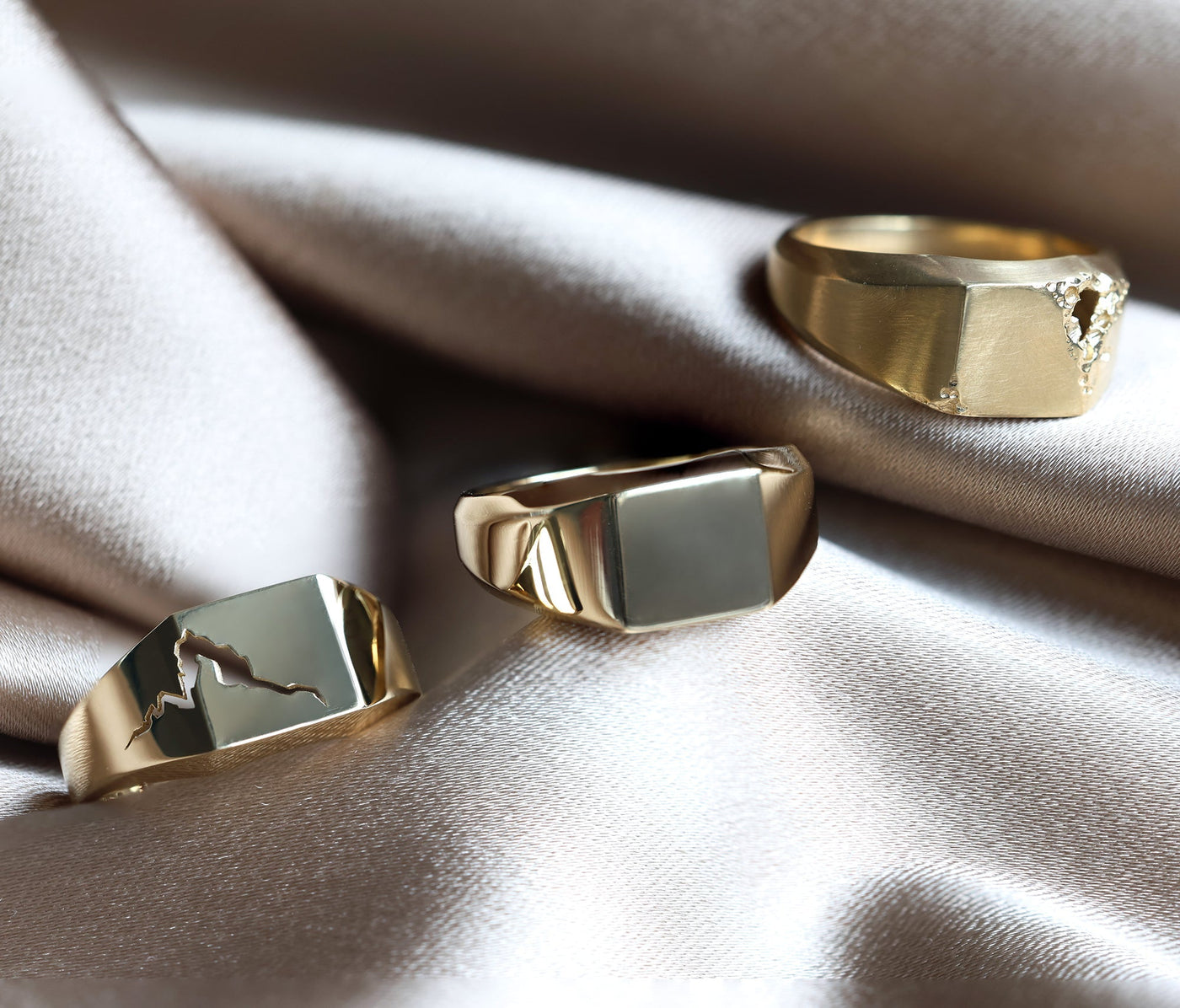 Close-up of a gold signet ring with a distinctive crack, showcasing premium metals like sterling silver, solid gold, and platinum.