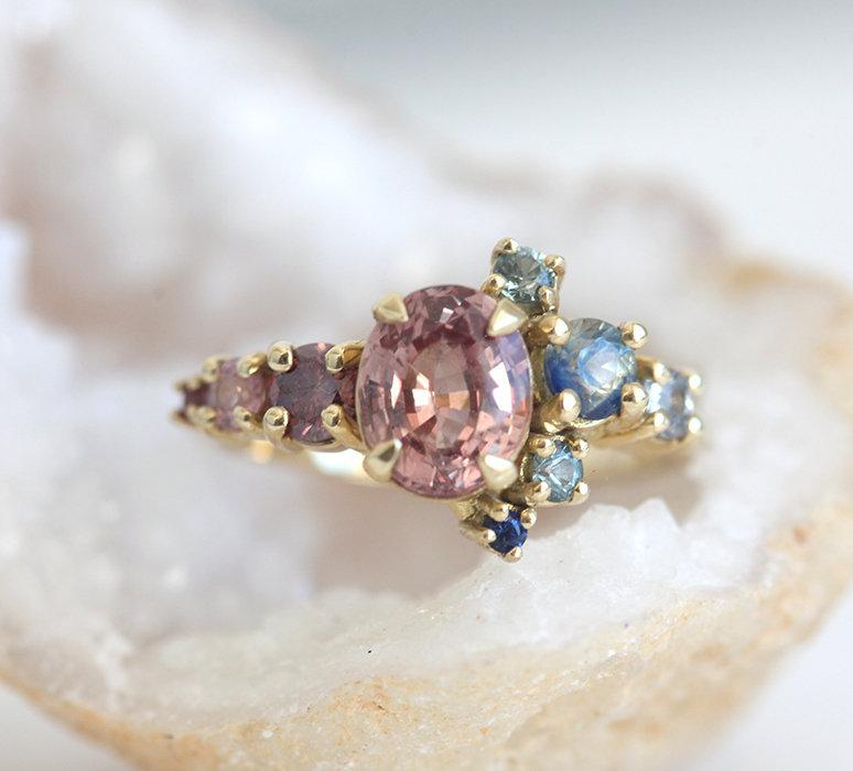 Oval-shaped peach sapphire and diamond cluster ring