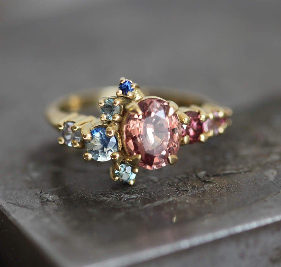 Oval-shaped peach sapphire and diamond cluster ring