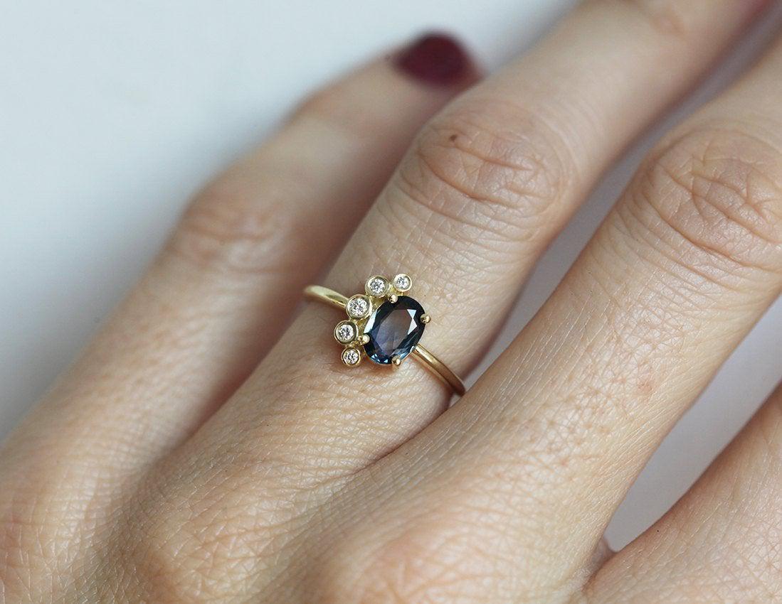 Oval-shaped sapphire cluster ring with side diamonds