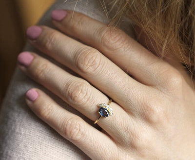 Oval-shaped sapphire cluster ring with side diamonds