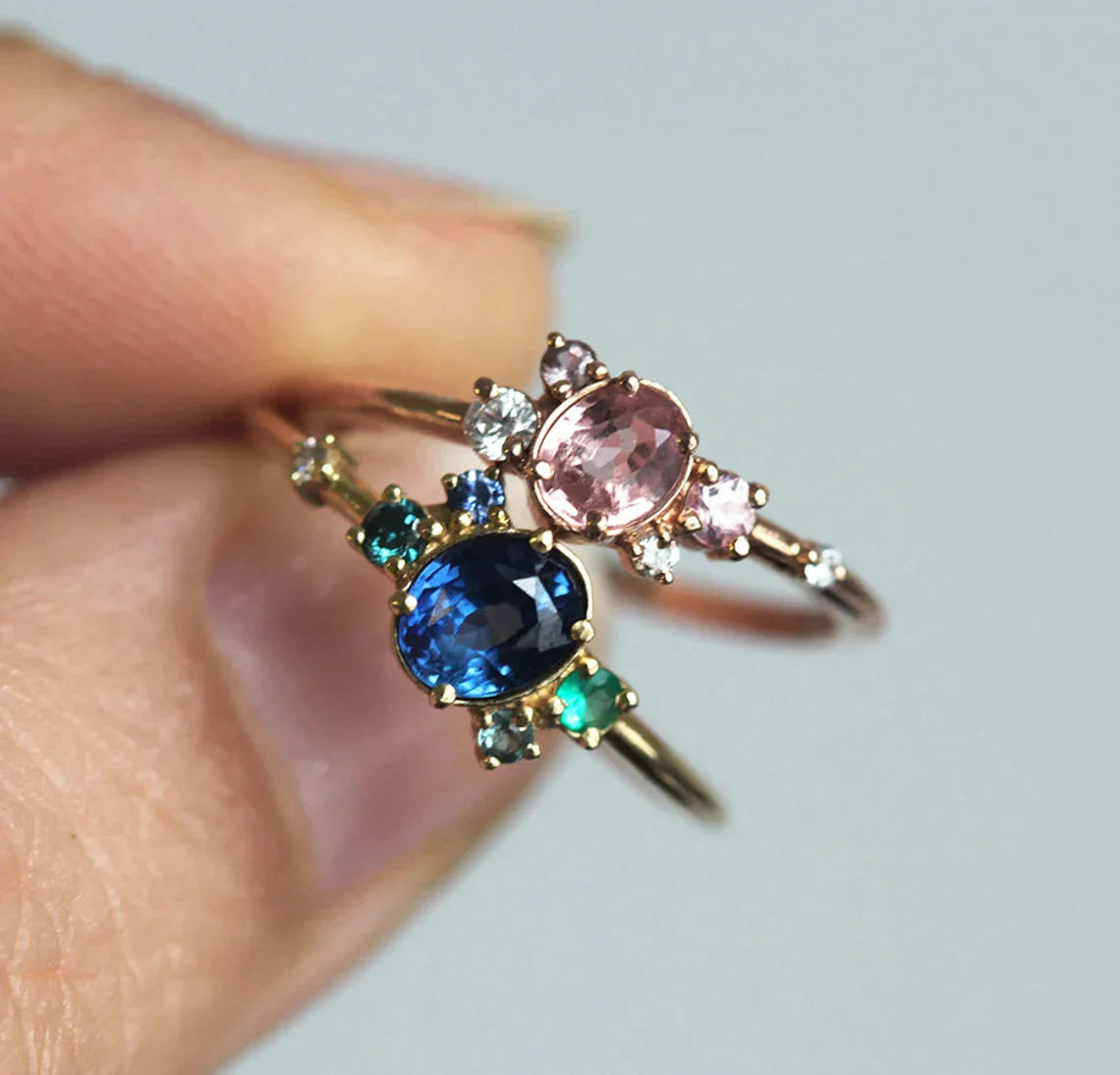 Pink and blue oval sapphire rings with cluster diamonds and amethyst