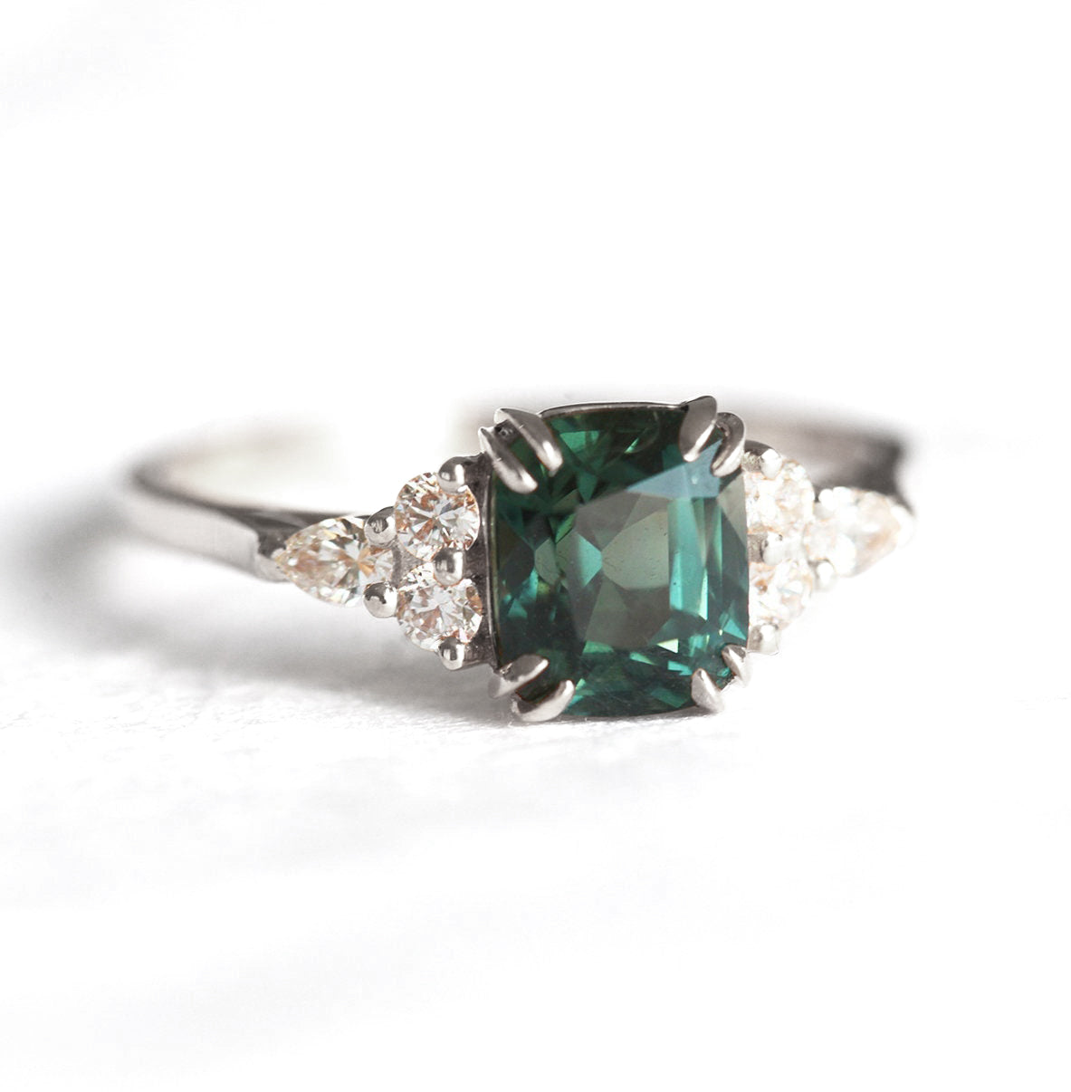 Cushion-cut teal sapphire cluster ring with diamonds