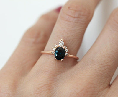 Teal oval-shaped sapphire ring with diamond halo
