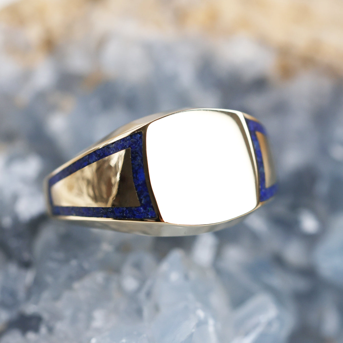 A close-up of a unique Crushed Lapis Signet Ring with inlay band.