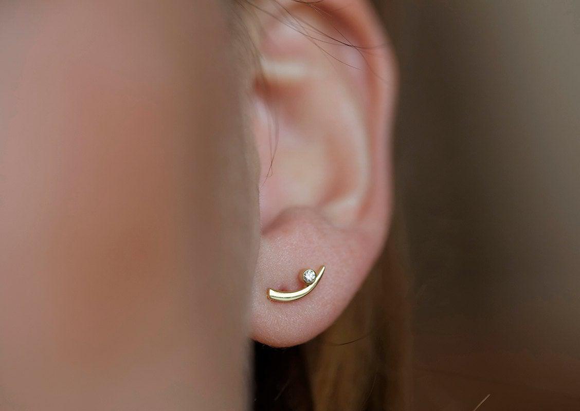 Claw-shaped stud earrings with round white diamonds