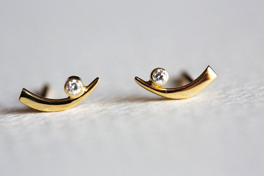 Claw-shaped stud earrings with round white diamonds