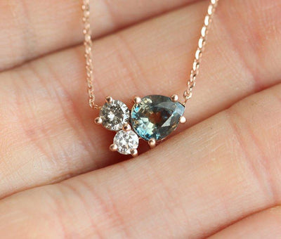 Pear-shaped teal sapphire and round diamond cluster gold necklace