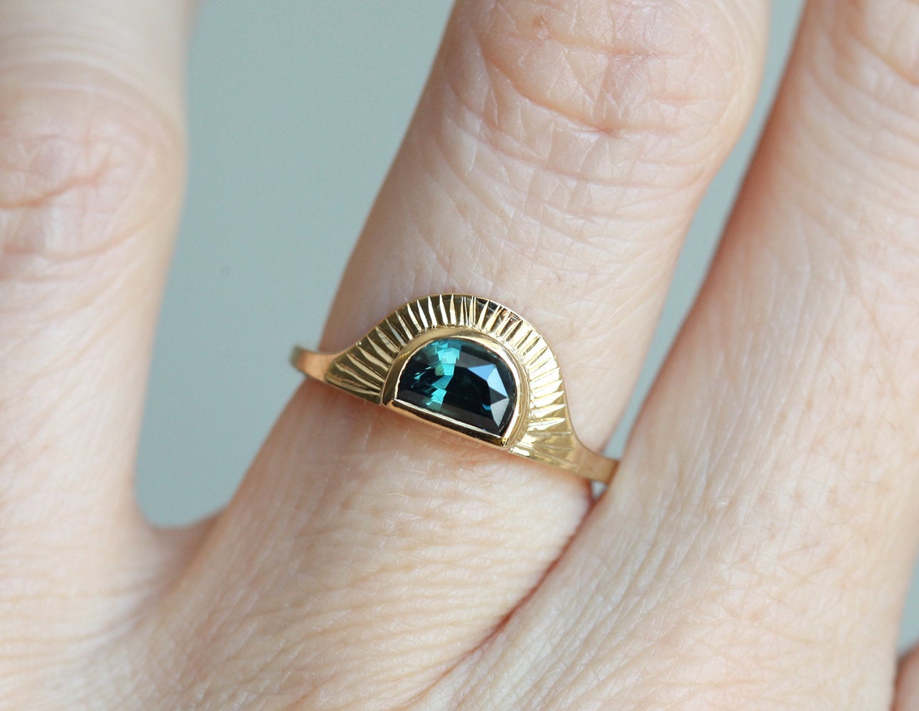 Half-moon-shaped teal sapphire ring