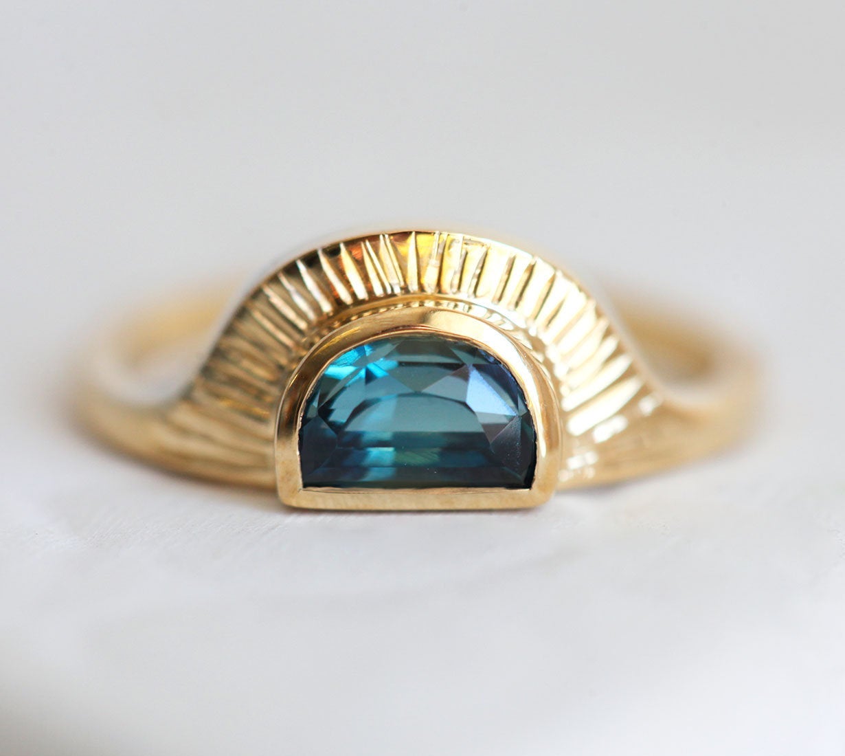 Half-moon-shaped teal sapphire ring