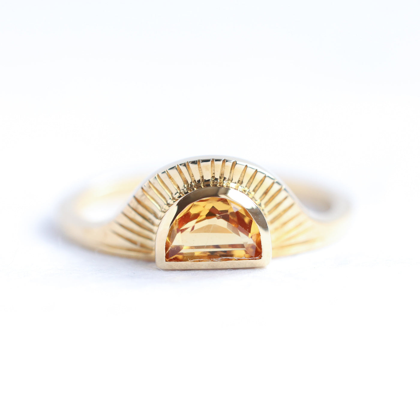 Half-moon-shaped golden orange sapphire ring