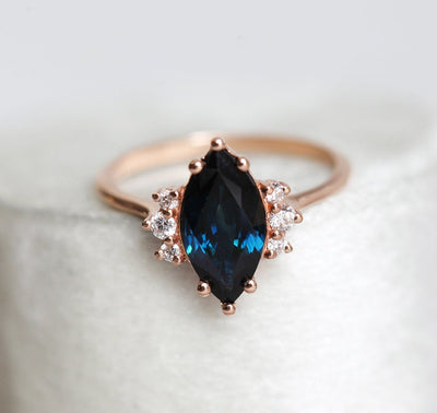 Marquise-shaped dark blue sapphire ring with white side diamonds