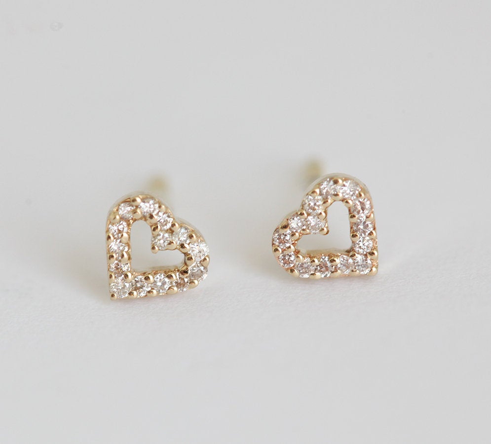 Heart-shaped gold stud earrings with round white diamonds