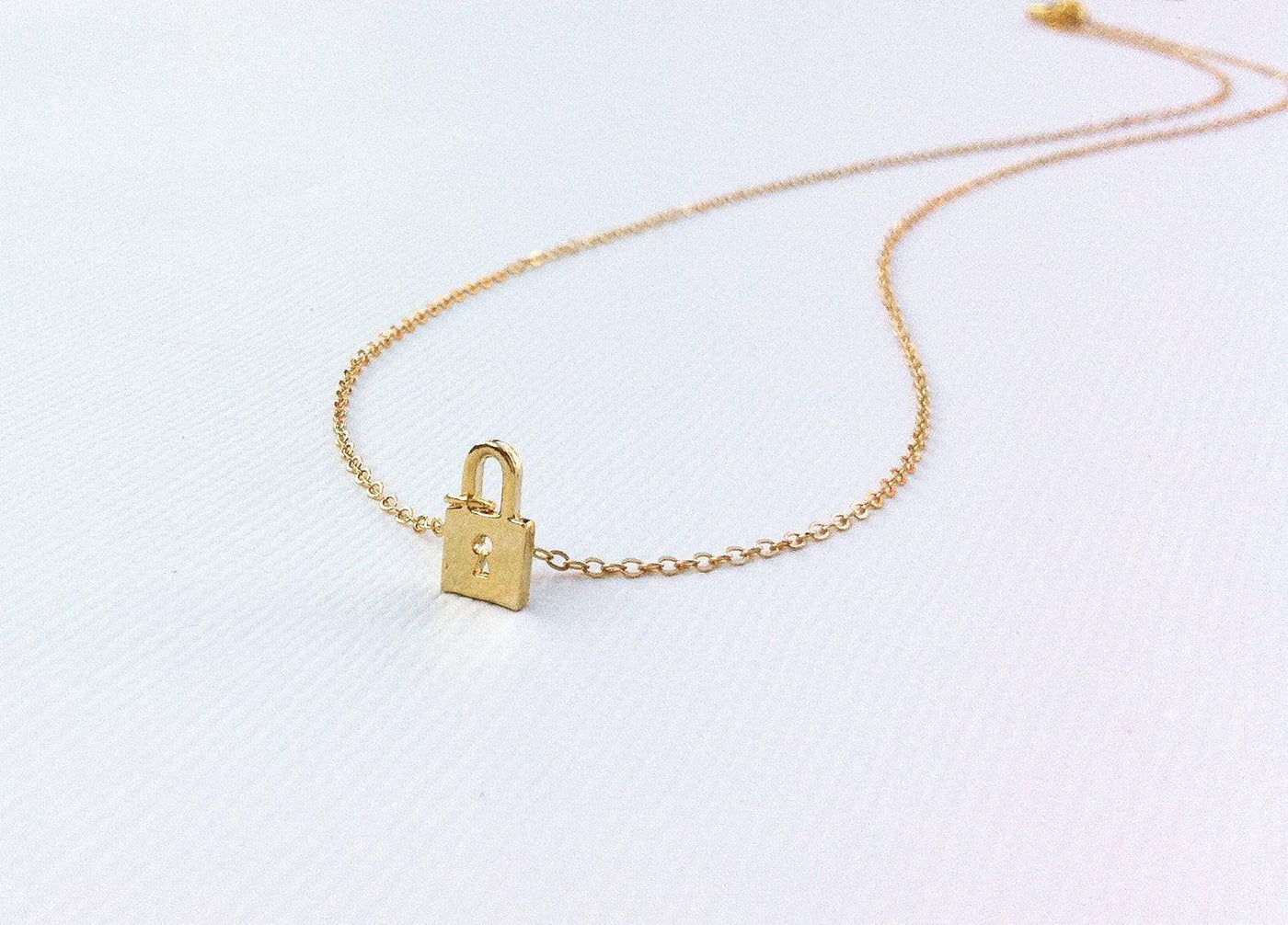 Gold necklace with small gold padlock