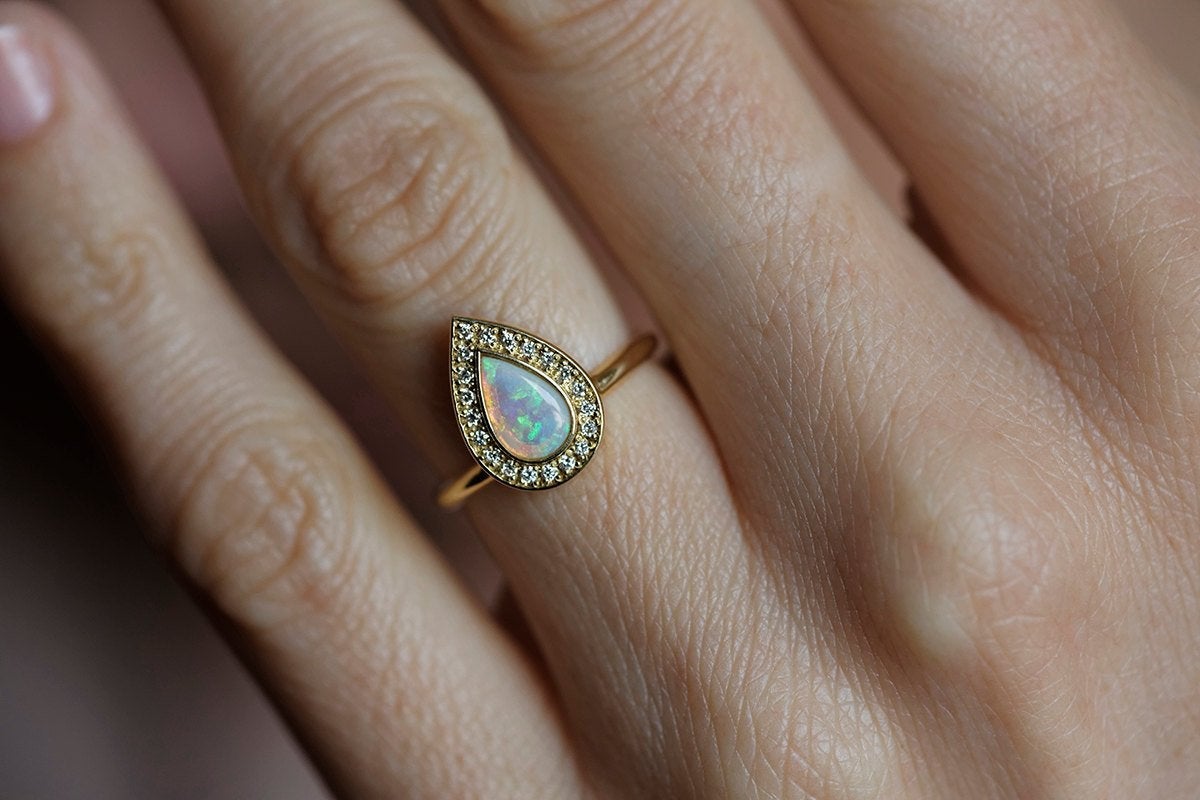 White Pear Opal Halo Yellow Gold Ring with Round White Diamonds Surrounding The Main Gemstone