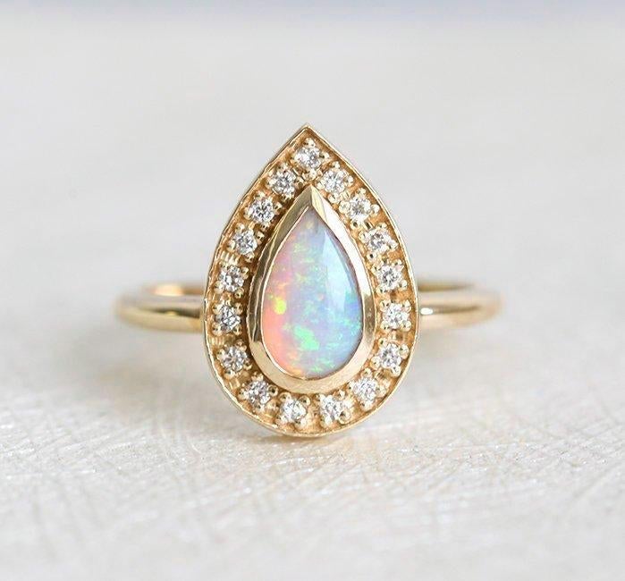 White Pear Opal Halo Yellow Gold Ring with Round White Diamonds Surrounding The Main Gemstone