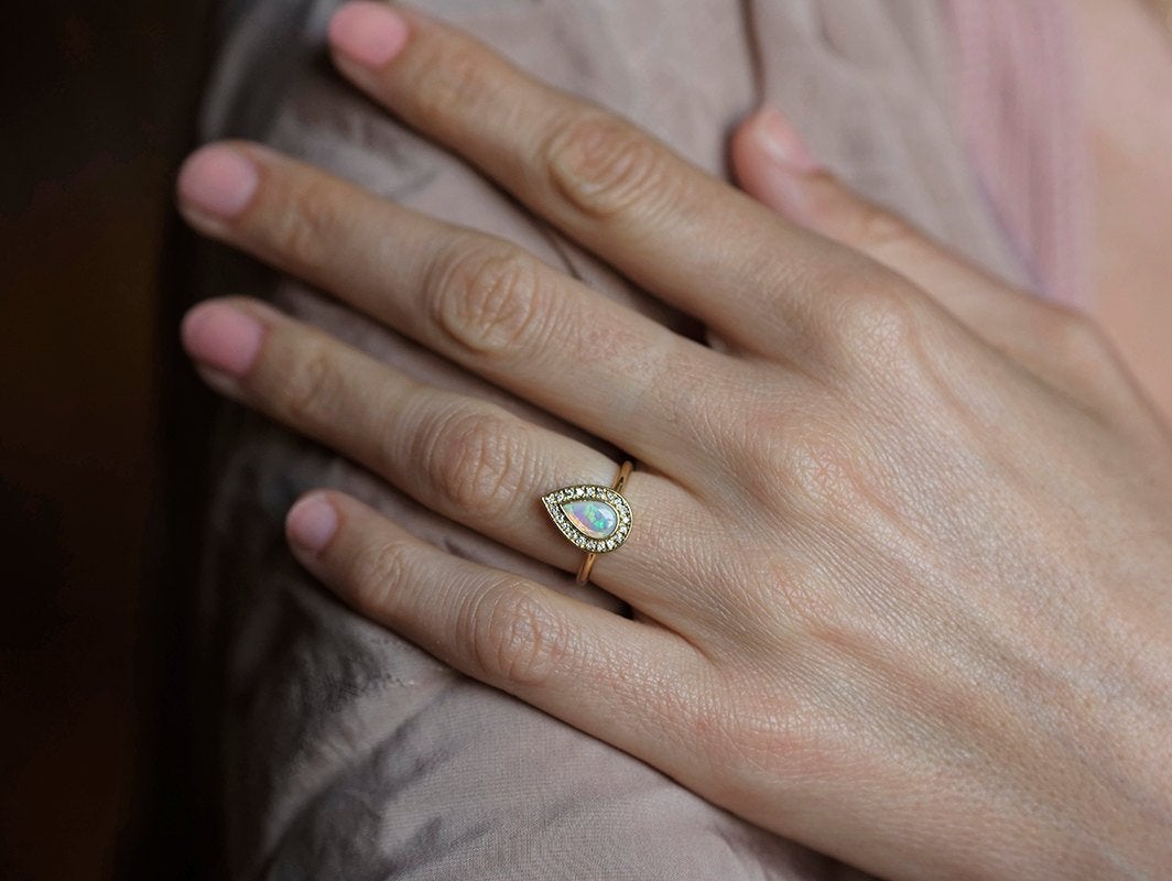 White Pear Opal Halo Yellow Gold Ring with Round White Diamonds Surrounding The Main Gemstone