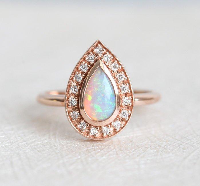 White Pear Opal Halo Rose Gold Ring with Round White Diamonds Surrounding The Main Gemstone