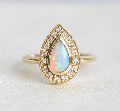 White Pear Opal Halo Yellow Gold Ring with Round White Diamonds Surrounding The Main Gemstone