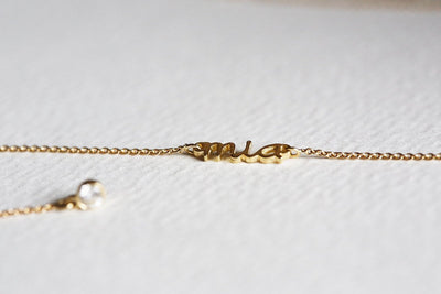 Gold lariat necklace with round white diamonds