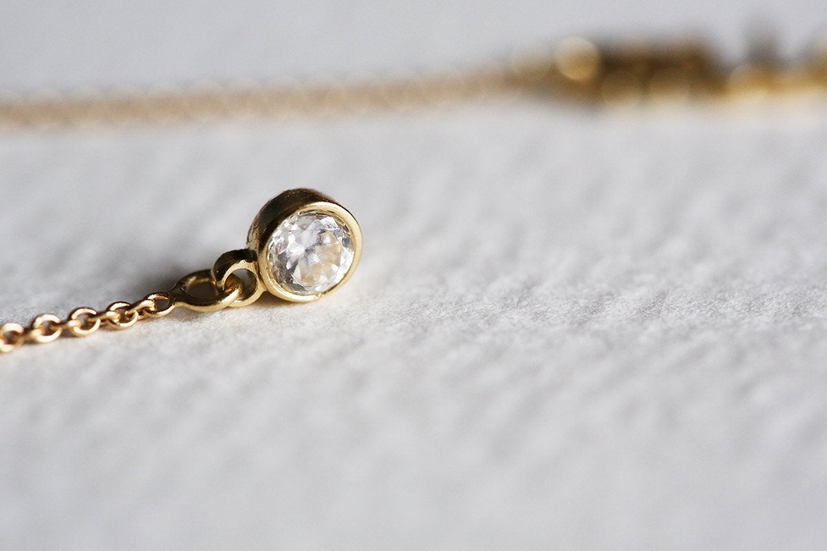 Gold lariat necklace with round white diamonds