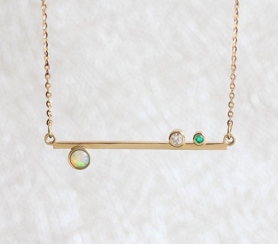 Gold bar necklace with round opal, diamond and emerald gemstones 