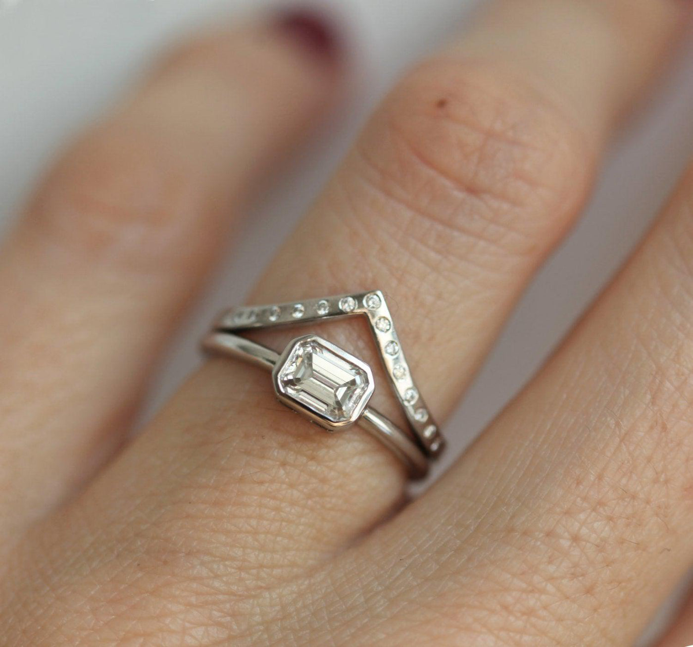 Emerald-Cut White Diamond with Upper V-Shape Diamond Ring making up a wedding ring