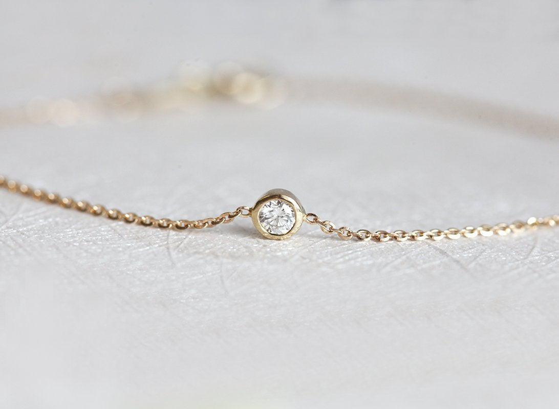 Bezel gold chain bracelet with round white diamond