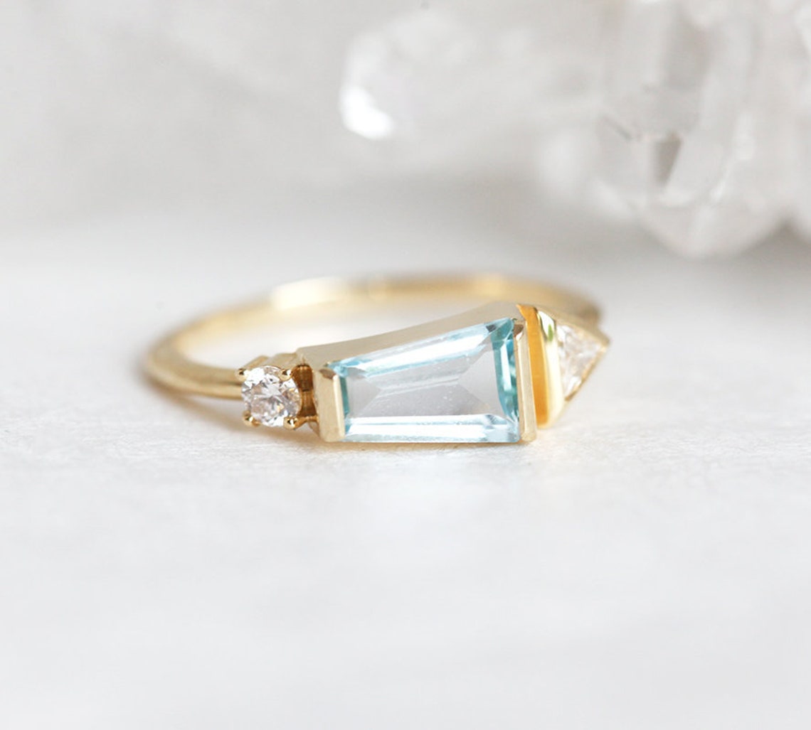 Light Blue Trapezoid Aquamarine Ring with Side Triangle White Diamond and a Round White Diamond