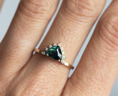 Trillion-shaped teal sapphire ring with diamond halo