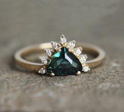 Trillion-shaped teal sapphire ring with diamond halo