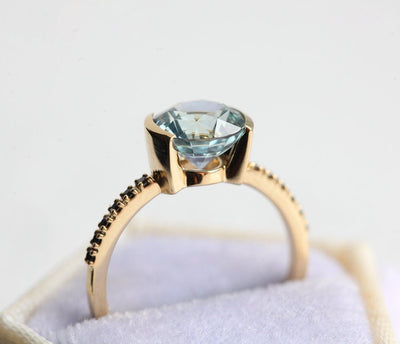 Round blue sapphire ring with black side diamond