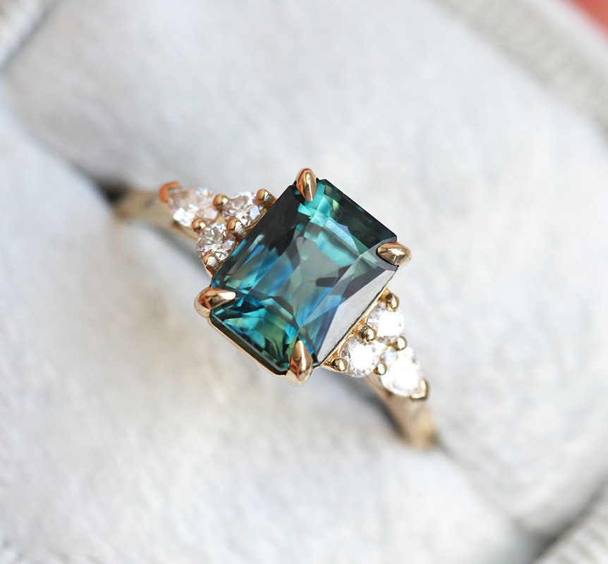 Radiant blue-green sapphire ring with side diamonds