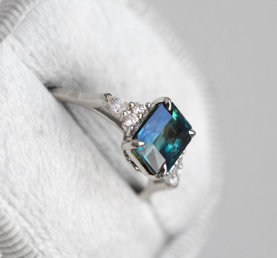 Radiant blue sapphire ring with diamond cluster