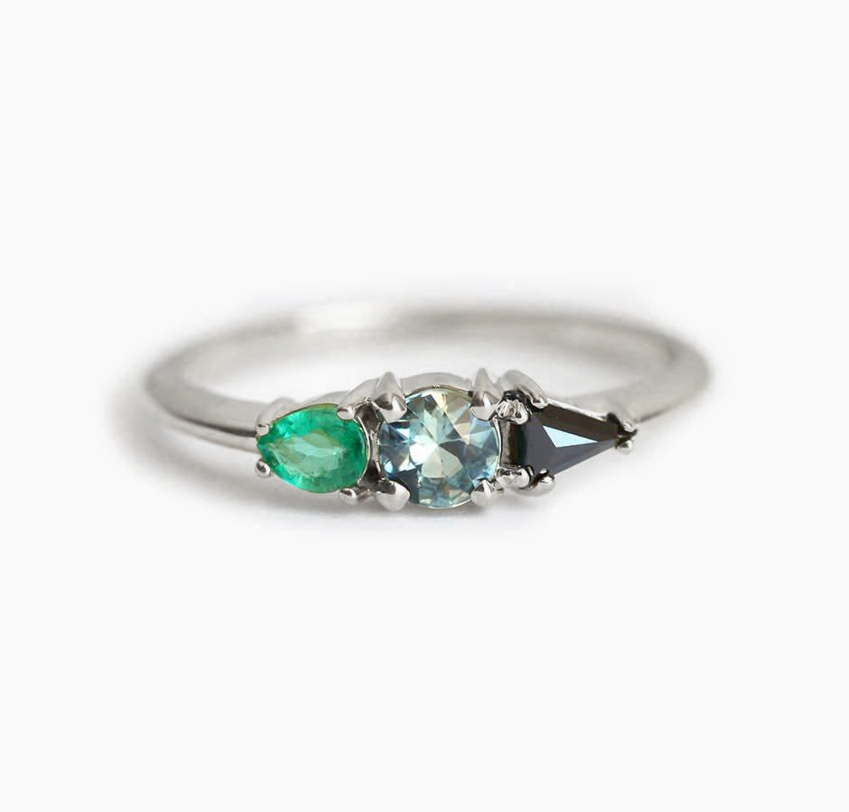 Round teal sapphire ring with black side diamond